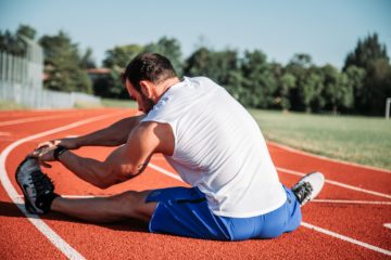 Man stretching before going running to avoid sports injury